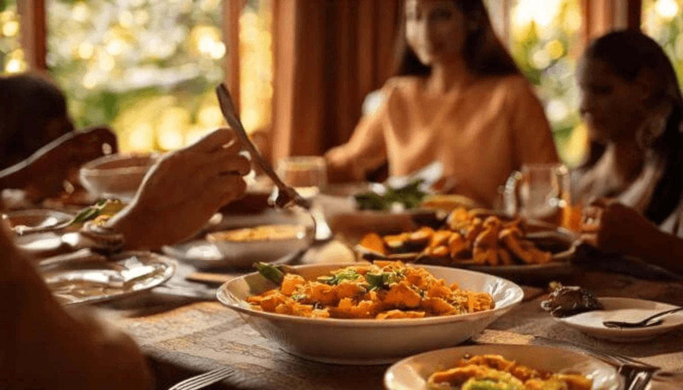 A family enjoying a holiday dinner featuring sweet potato casserole, served alongside roasted vegetables, salad, and drinks on a warmly lit table.